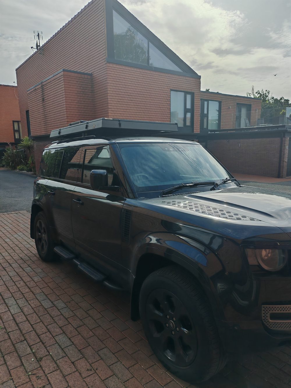 Closed slim roof tent on a Defender roof rack