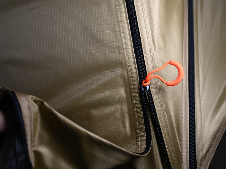 Close-up of a heavy zip with an orange pull