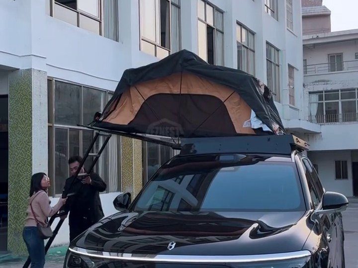 AITO M9 with the roof tent open and two people at the ladder