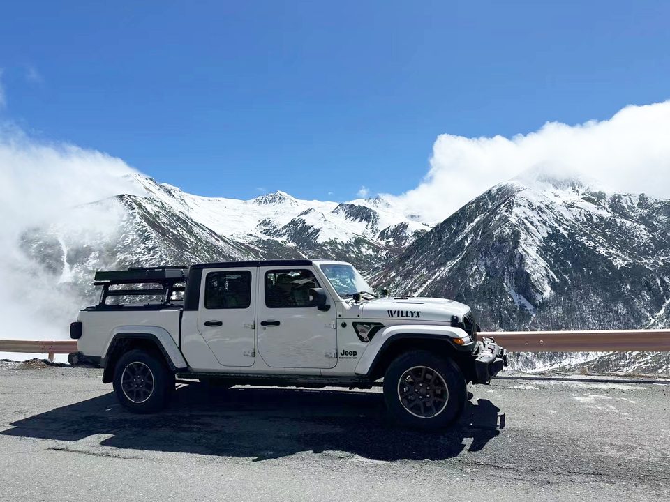 Small roof tent closed on the bed rack of a white Jeep Gladiator