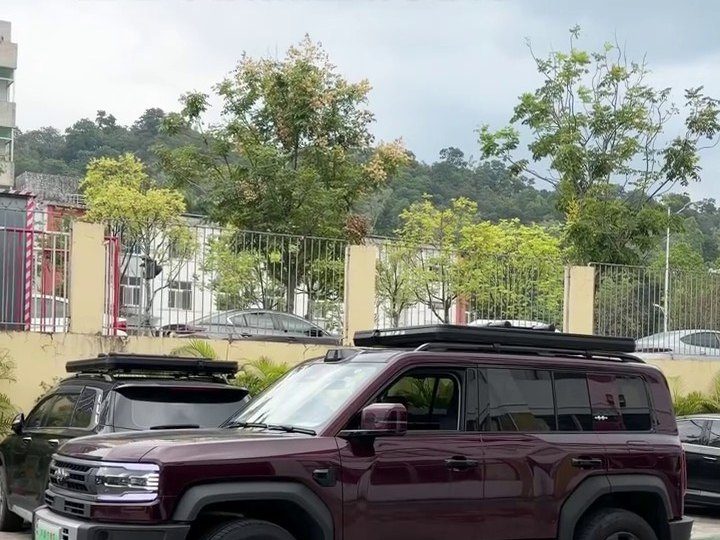Closed roof tent low on the roof of a maroon Fangchengbao Leopard 5