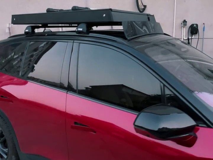 Closed roof tent on the roof of a red NIO ES6