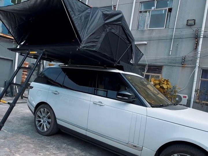 Side view of a white Range Rover with the roof tent open