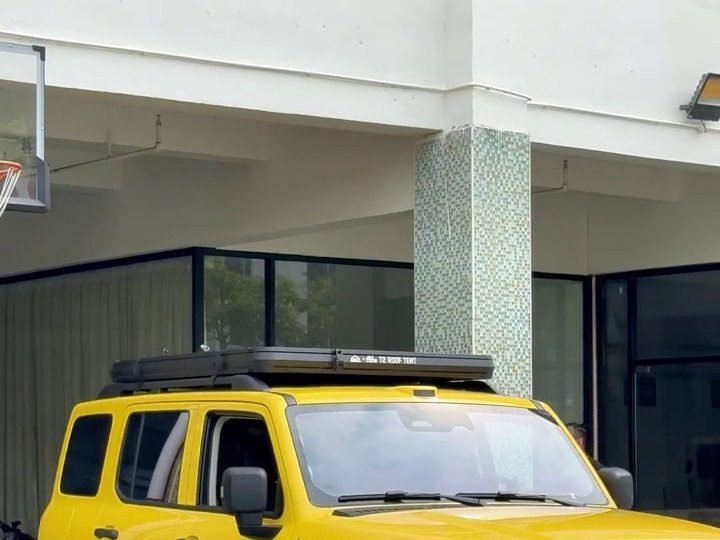 Closed roof tent low on the roof of a yellow GWM Tank 300
