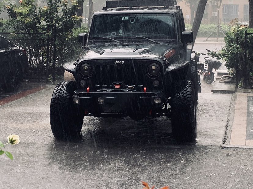 Jeep Wrangler with the roof tent closed, parked in the rain