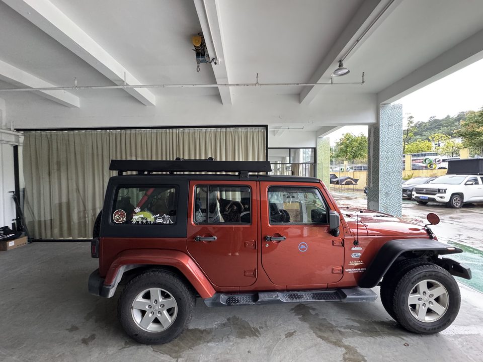 Red Jeep Wrangler with the roof tent closed flat on its roof rack