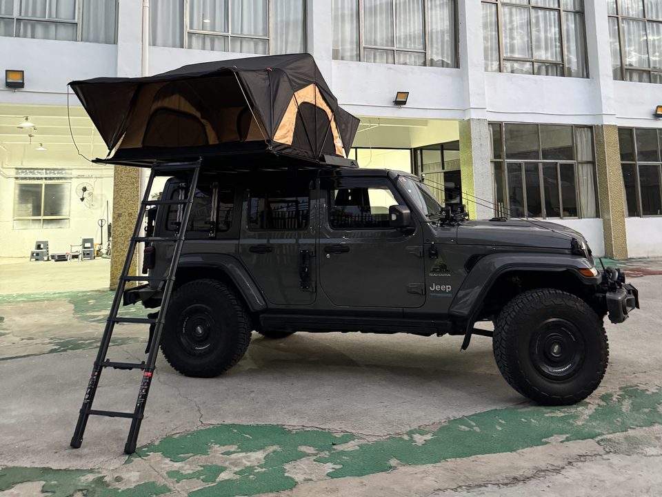 Roof tent open on a grey Jeep Wrangler with the ladder down